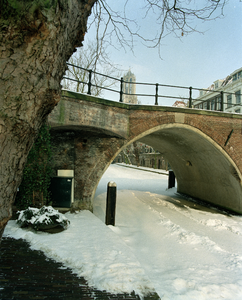 805683 Gezicht op de Hamburgerbrug over een bevroren en besneeuwde Oudegracht te Utrecht.